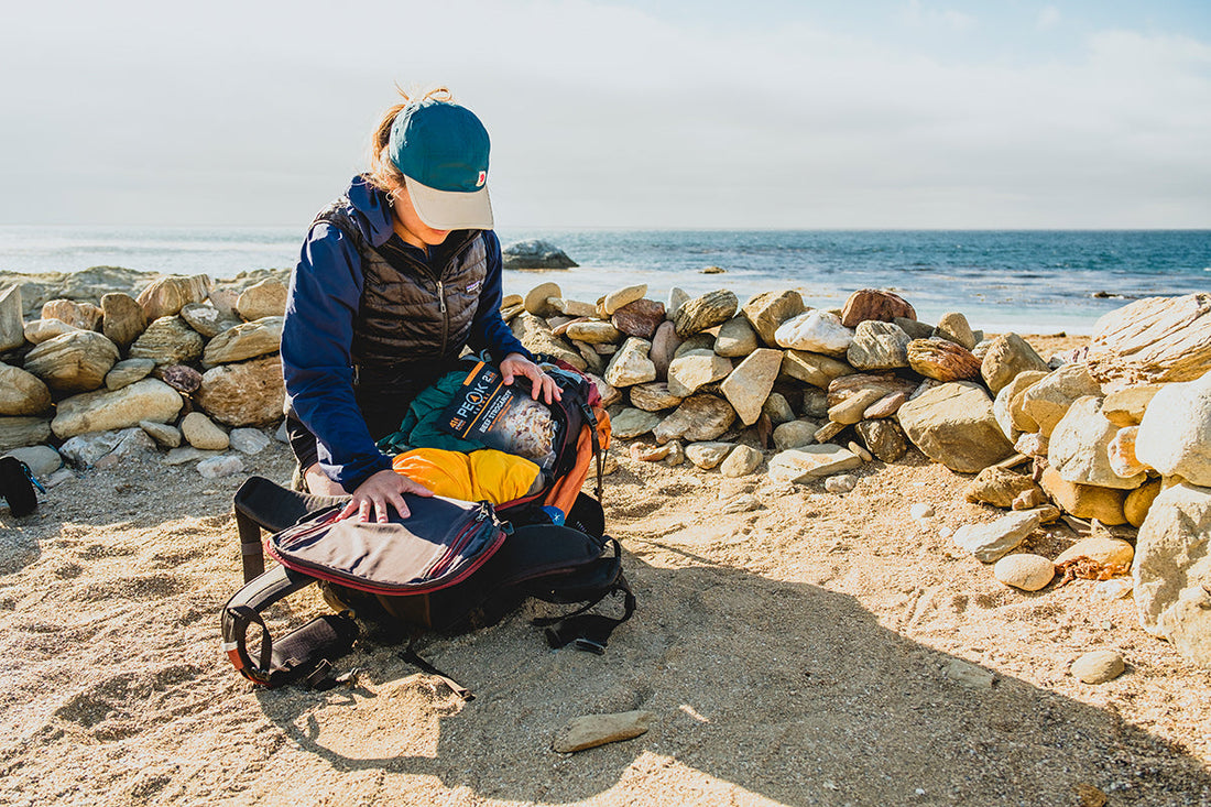 A backpacker showing the Outro Backpacking pack open and ready for the evening camp backpacking experience