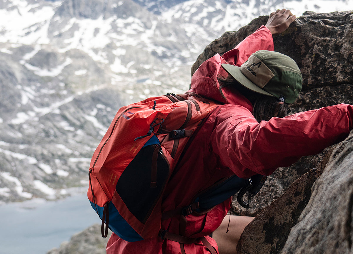 Pingora Lucid 20 litre hiking backpack shown on model climbing a mountain