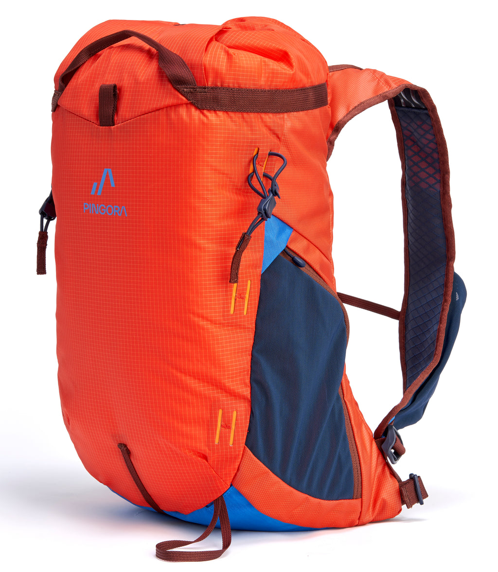 A Pingora Focus 15 liter red and blue climbing backpack with multiple zippers and side straps.