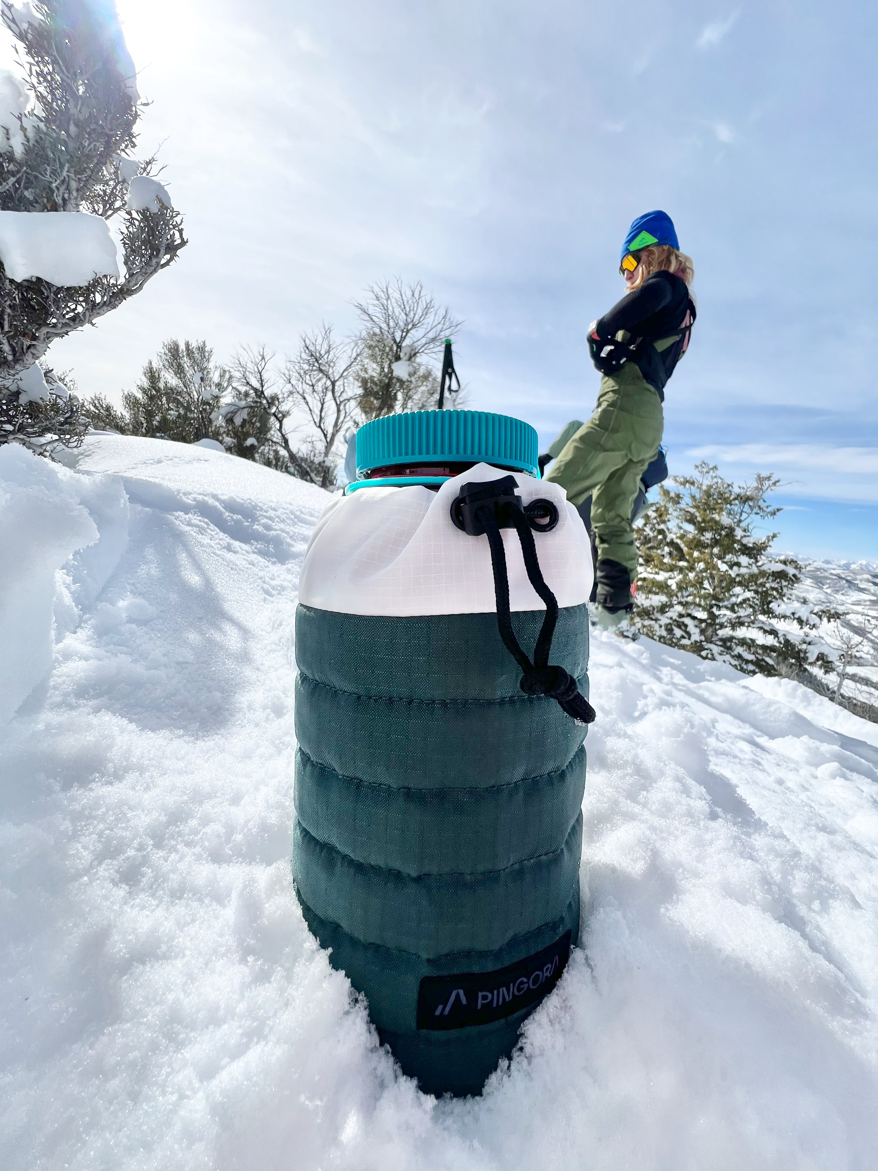 A Pingora puffy bottle holder showing a polycarbonate bottle inside the holder set upon the snow