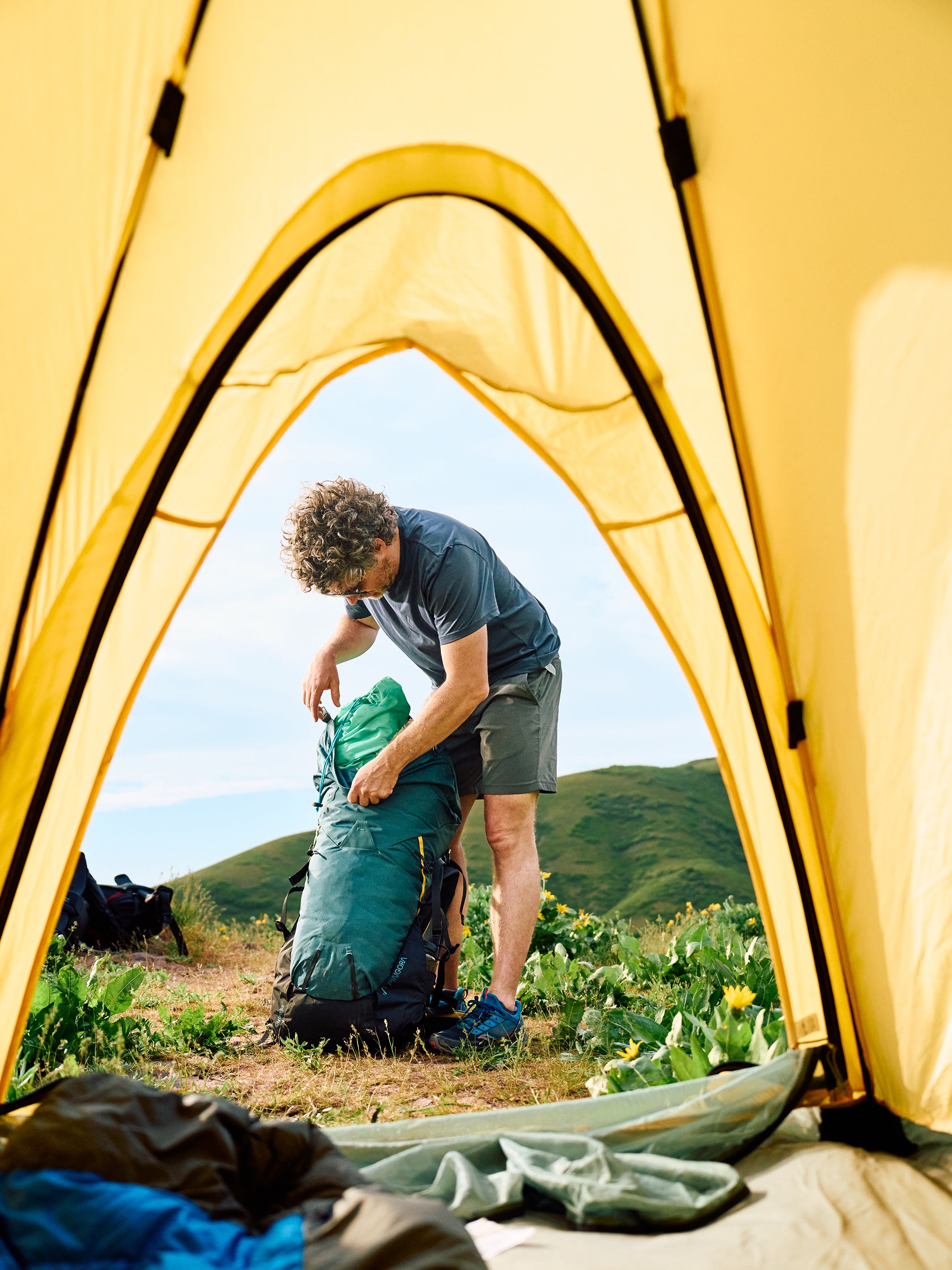 Outro backpacking backpack showing model packing the bag